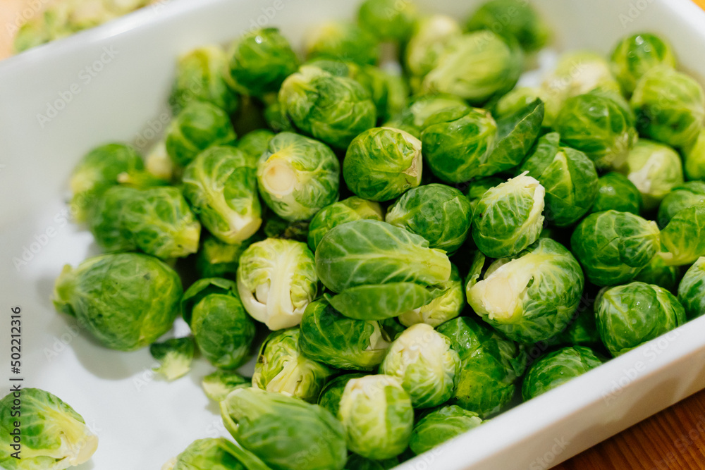 White dish with fresh green Brussels sprouts. Top view, close-up. Healthy food concept. White dish with fresh green Brussels sprouts. Top view, close-up. Healthy food concept.