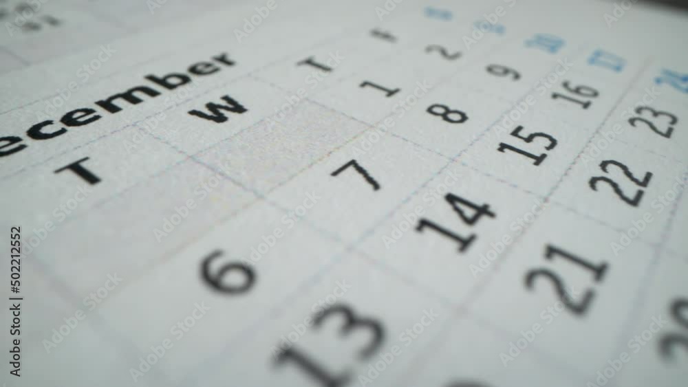 December page of 2022 wall calendar followed by the January page of a new 2023 calendar. Calendar of this year. Macro shot of many dates, business days and holidays. Cristmas time