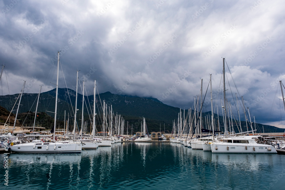 Beautiful cloudy sky and sea view. Luxury yacht boat marina at Datca in Mugla, Turkey. Moody weather reflecting on water surface. Nautical background with copy space.