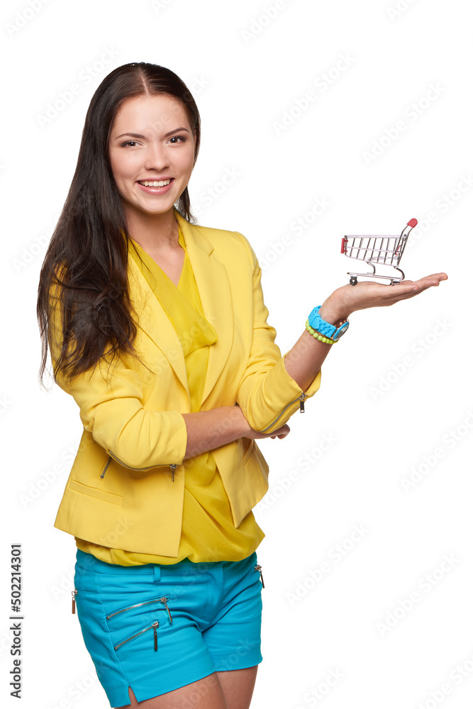 Smiling casual woman standing with small empty shopping cart basket on her palm Smiling casual woman standing with small empty shopping cart basket on her palm