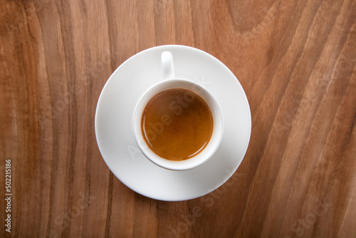 White cup of espresso on wooden background,top view