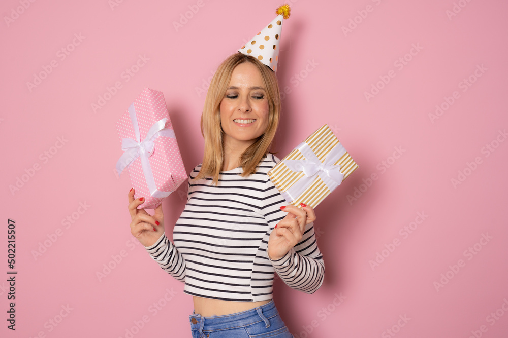 Portrait of a smiling pretty young woman holding gift boxes isolated over pink background Portrait of a smiling pretty young woman holding gift boxes isolated over pink background