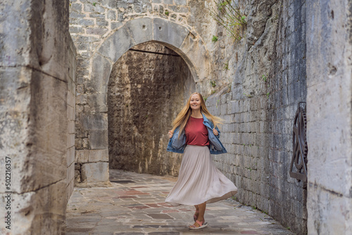 Woman tourist enjoying Colorful street in Old town of Kotor on a sunny day, Montenegro. Travel to Montenegro concept