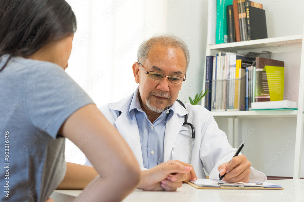 Old doctor in professional uniform examining young patient woman at hospital or medical clinic. Health care , medical and doctor staff service concept. Old doctor in professional uniform examining young patient woman at hospital or medical clinic. Health care , medical and doctor staff service concept.