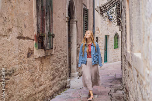 Woman tourist enjoying Colorful street in Old town of Kotor on a sunny day, Montenegro. Travel to Montenegro concept