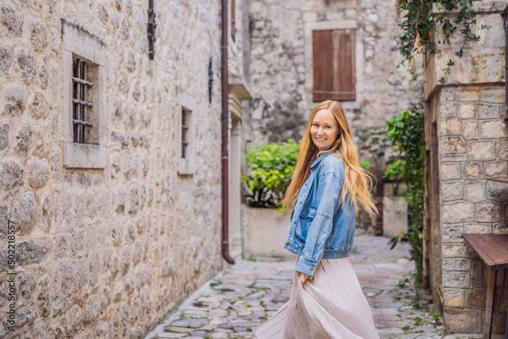 Woman tourist enjoying Colorful street in Old town of Kotor on a sunny day, Montenegro. Travel to Montenegro concept