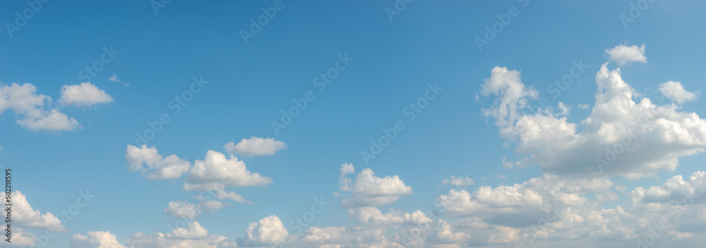 Banner with panoramic view over deep blue clean sky with illuminated clouds as a background. - obrazy, fototapety, plakaty 