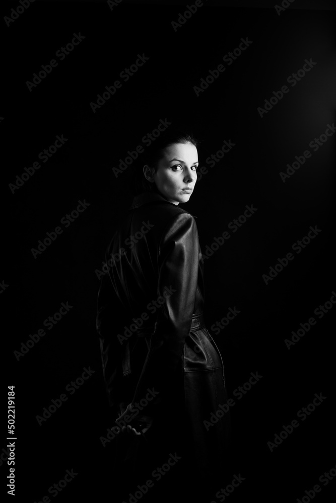 woman with closed eyes in leather coat and, black background