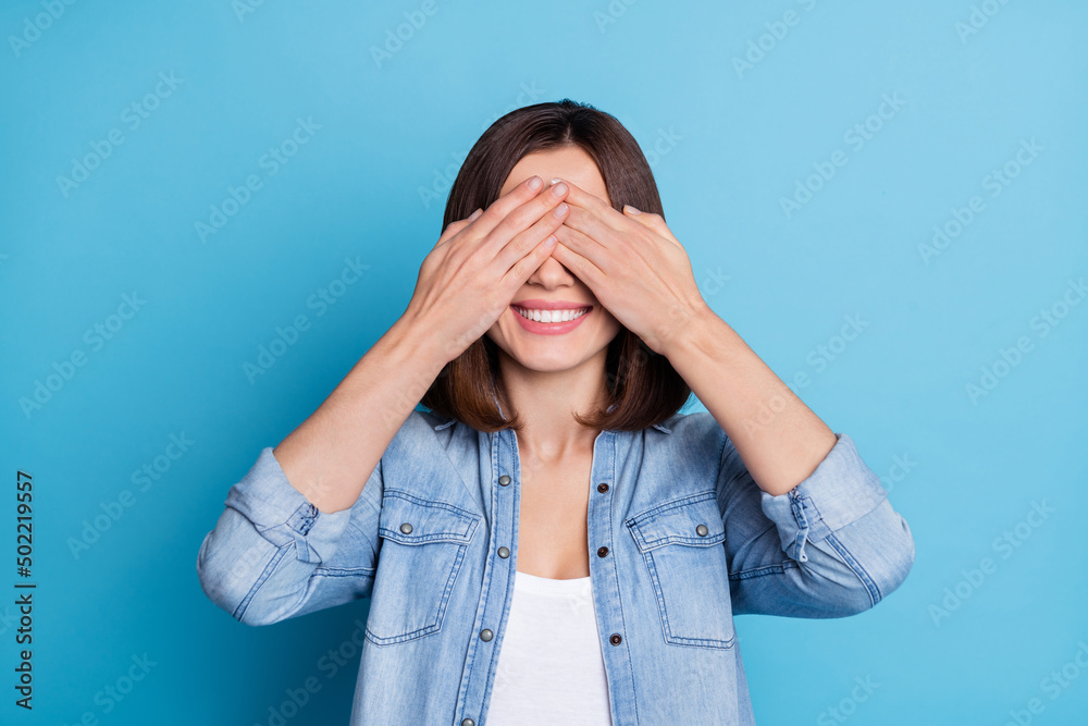 Photo of funny childish woman wear jeans shirt arms close eyes playing hide-and-seek isolated blue color background Photo of funny childish woman wear jeans shirt arms close eyes playing hide-and-seek isolated blue color background