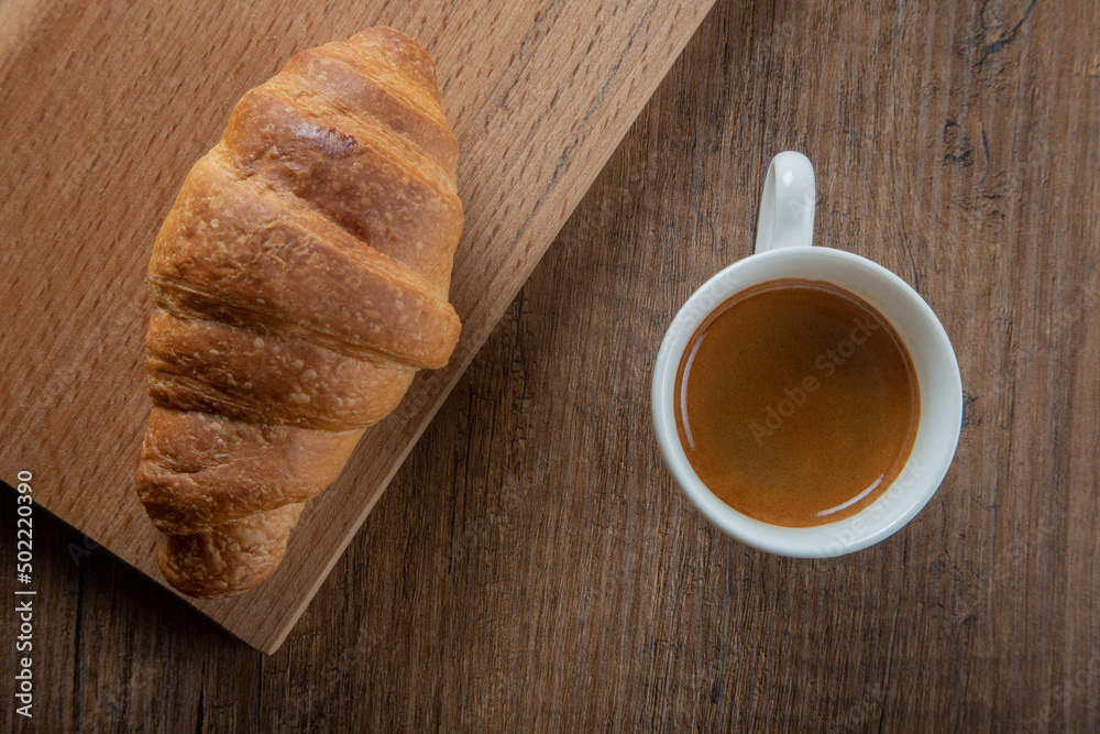 Croissant with espresso in white cup,top view Croissant with espresso in white cup,top view