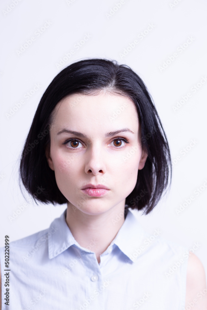 woman in a blue sleeveless office shirt, light background woman in a blue sleeveless office shirt, light background
