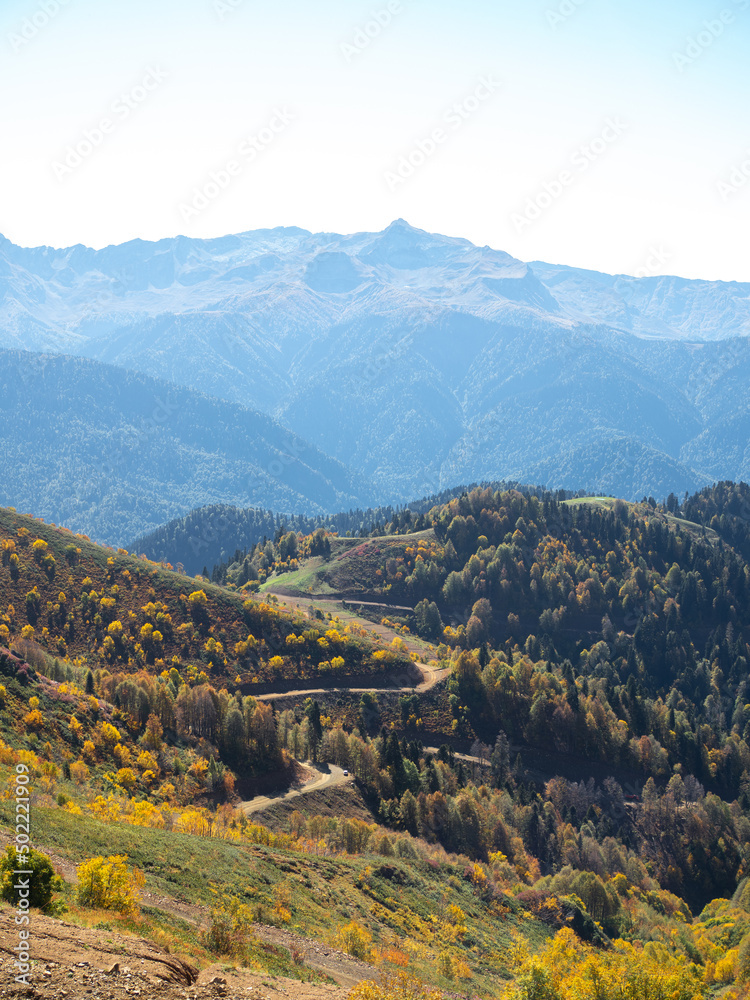 Fototapeta premium Mountain trails. beautiful panorama of mountains, aerial perspective, distant peaks in a blue haze, freedom and beauty of nature. Autumn view of the Caucasus mountains in Russia