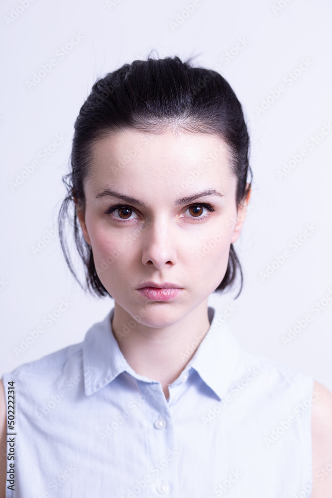 woman in a blue sleeveless office shirt, light background woman in a blue sleeveless office shirt, light background