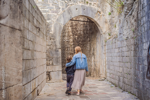 Mom and son travelers enjoying Colorful street in Old town of Kotor on a sunny day, Montenegro. Travel to Montenegro concept