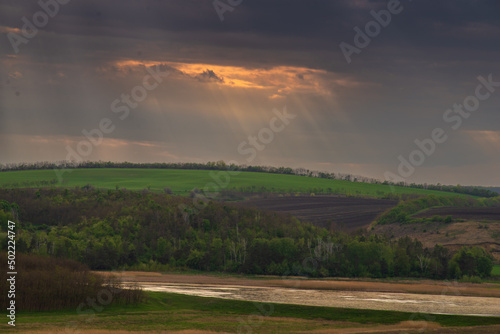 Green meadow  trees and rolling hills at sunset. forest  lake  sun rays  Moldova  Surchiceni
