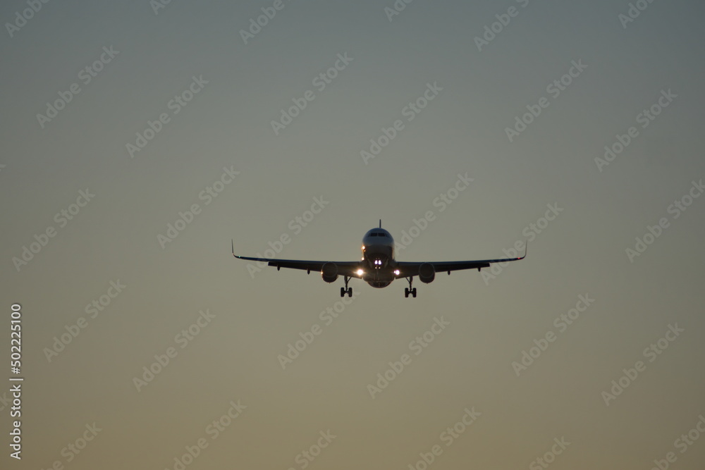 Commercial jet flying, in silhouette, in the evening, in Fort Lauderdale, Florida, USA Commercial jet flying, in silhouette, in the evening, in Fort Lauderdale, Florida, USA