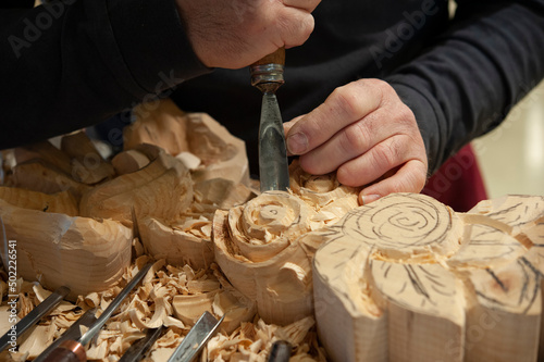 Master woodcarver at work. Wood shavings, gouges and chisels on the workbench. photo
