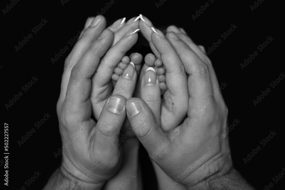 tender little legs of a newborn baby in the hands of mom and dad. tender little legs of a newborn baby in the hands of mom and dad.
