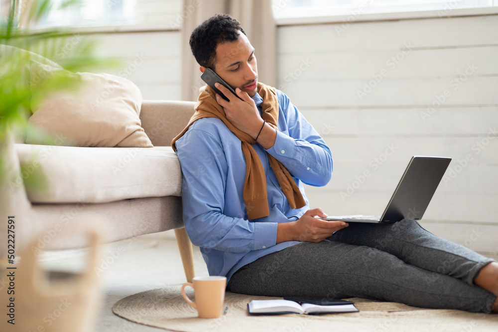 Arab man working and talking on phone at home Arab man working and talking on phone at home