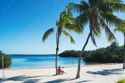 Woman sunbathing on beach at John Pennekamp state park in Key Largo, Florida photo