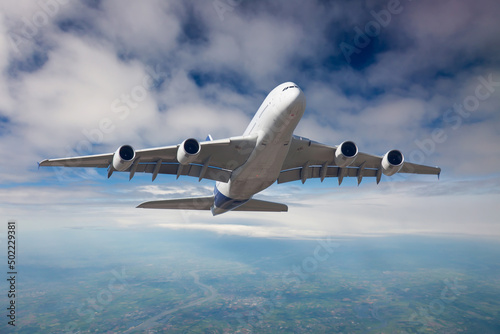 The passenger plane in flight. Aircraft climb into the blue sky above the clouds. Front view of aircraft.