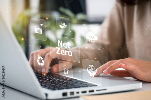 women hand using laptop for working technology and business Net zero and carbon neutral concept.NET ZERO icons and symbols save the eco world and reduce pollution. greenhouse gas emissions target.