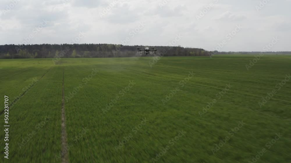 Agro drone works on the field. Field treatment with chemicals. Spraying pesticides against pests. Innovations in the agricultural sector. New technologies. Aerial. Agro drone works on the field. Field treatment with chemicals. Spraying pesticides against pests. Innovations in the agricultural sector. New technologies. Aerial.