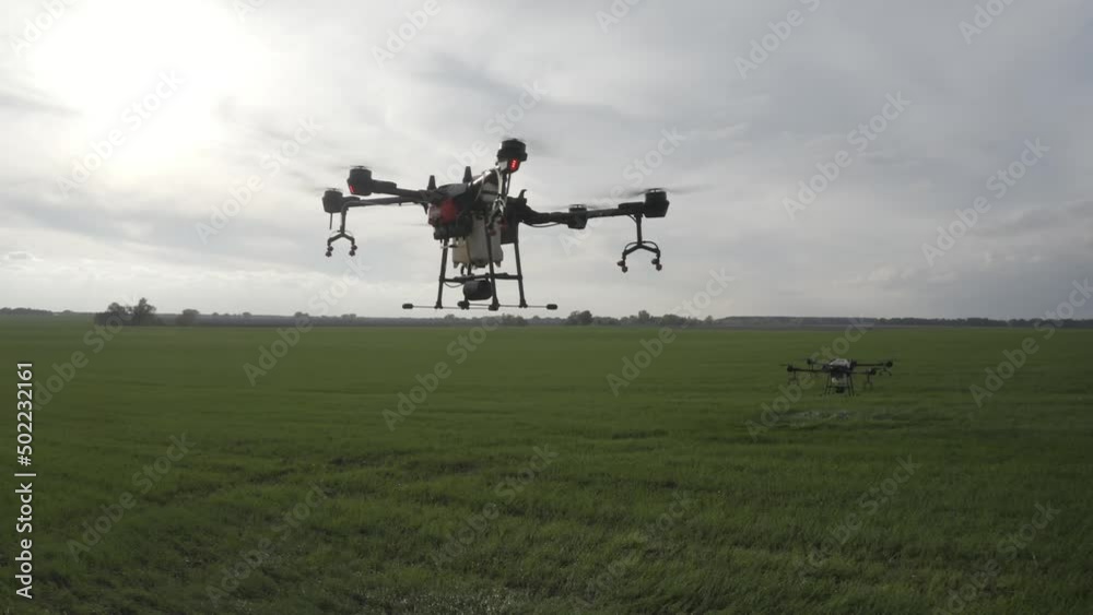 Agro drone works on the field. Field treatment with chemicals. Spraying pesticides against pests. Innovations in the agricultural sector. New technologies. Aerial. Agro drone works on the field. Field treatment with chemicals. Spraying pesticides against pests. Innovations in the agricultural sector. New technologies. Aerial.