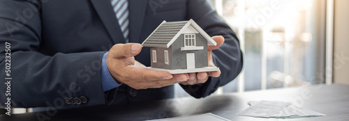 Sales manager or real estate agent prepares to hand over the keys and the house together with the insurance to the customer, Attention to property services and insurance concept.