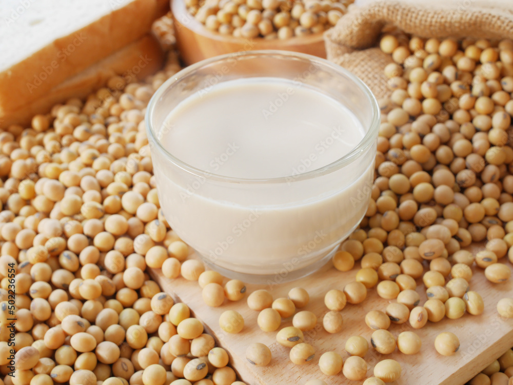 Delicious hot soy milk with sack of soy beans on wooden cutting board Delicious hot soy milk with sack of soy beans on wooden cutting board