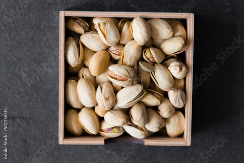 Roasted Pistachios as detailed close-up shot (selective focus) on wooden background