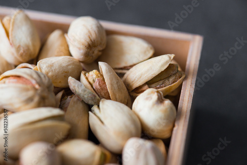 Roasted Pistachios as detailed close-up shot (selective focus) on wooden background