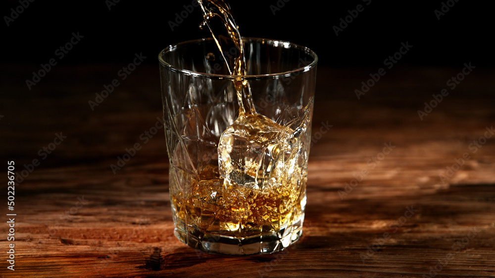 Detail of pouring whisky into glass. Detail of pouring whisky into glass.