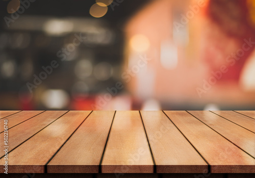 Empty wooden table top with lights bokeh on blur restaurant background. 