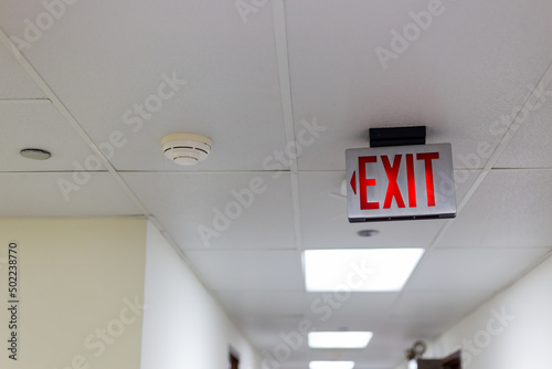 red emergency exit sign in the dark room. illuminated office exit sign.