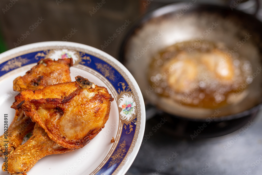 Fried chicken in a plate with a gas stove background Fried chicken in a plate with a gas stove background