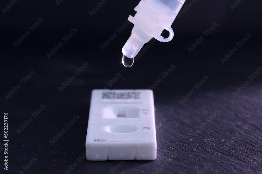 Dropper for a covid 19, lateral flow test. Focus is on dropper with the generic test cassette