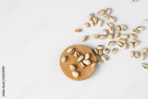 Pistachios with and without shell on white wooden surface