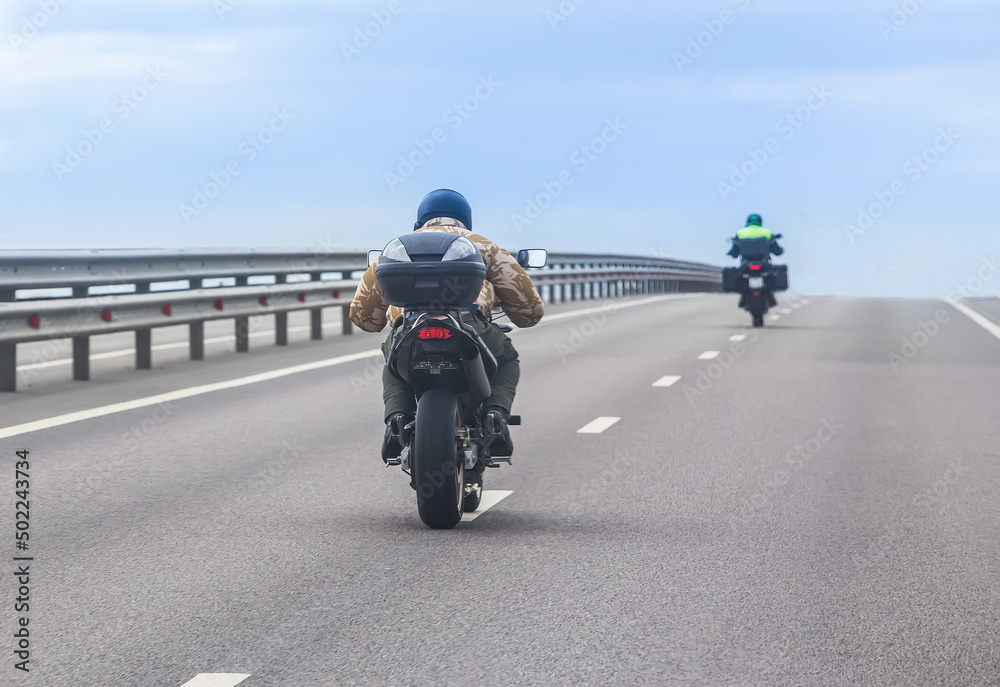 Obraz premium Motorcyclists on bikes ride on a country road.