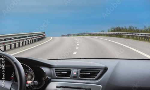 View from the windshield of a car driving along road