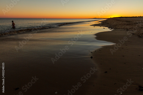 Long shot of a pretty woman in a sunset beach