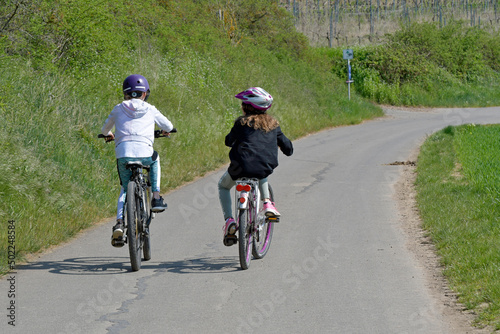 Fototapeta Naklejka Na Ścianę i Meble -  kinder fahren auf einem feldweg fahrrad