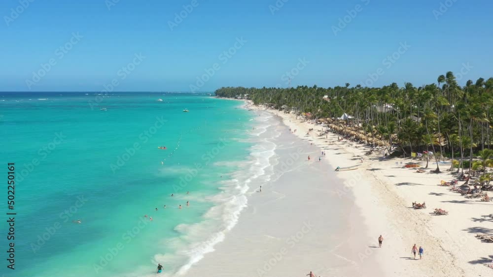 Pristine and bounty coastline with resorts, palm trees, caribbean sea and people having fun on beach. Travel destinations. Dominican Republic. Aerial view Pristine and bounty coastline with resorts, palm trees, caribbean sea and people having fun on beach. Travel destinations. Dominican Republic. Aerial view