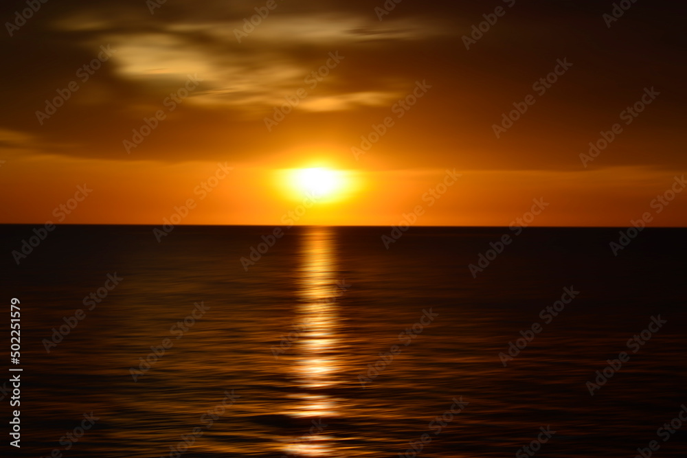 Sunset over the ocean. Blurry abstract art background in digital motion effect.