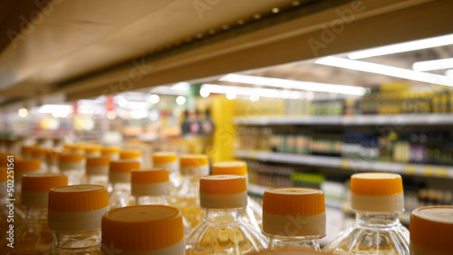 Many bottles of sunflower oil on a store shelf close-up