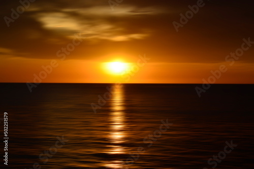 Sunset over the ocean. Blurry abstract art background in digital motion effect. © Jenn Miranda