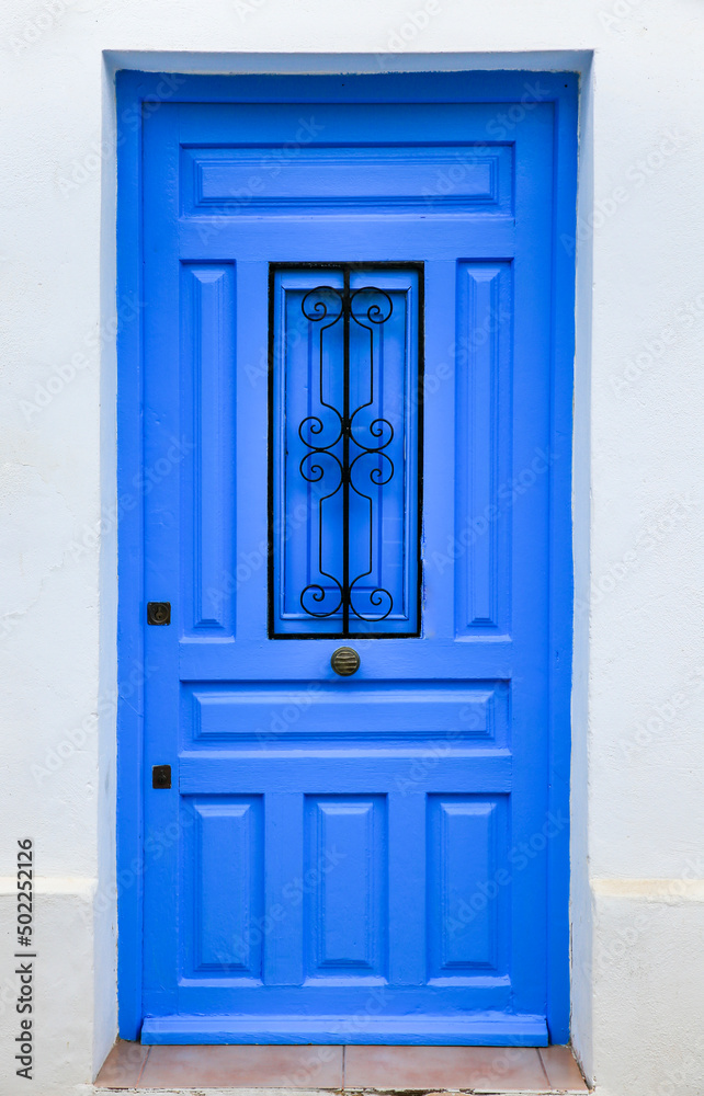 Blue wooden door and whitewashed facade in Altea