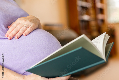 Pregnant woman reading a book on parenting and sleep
