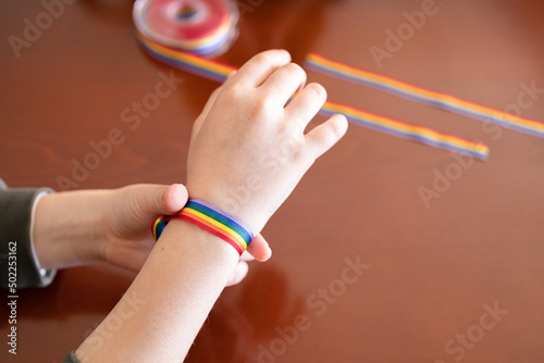 Young girl hand with a LGBT rainbow bracelet