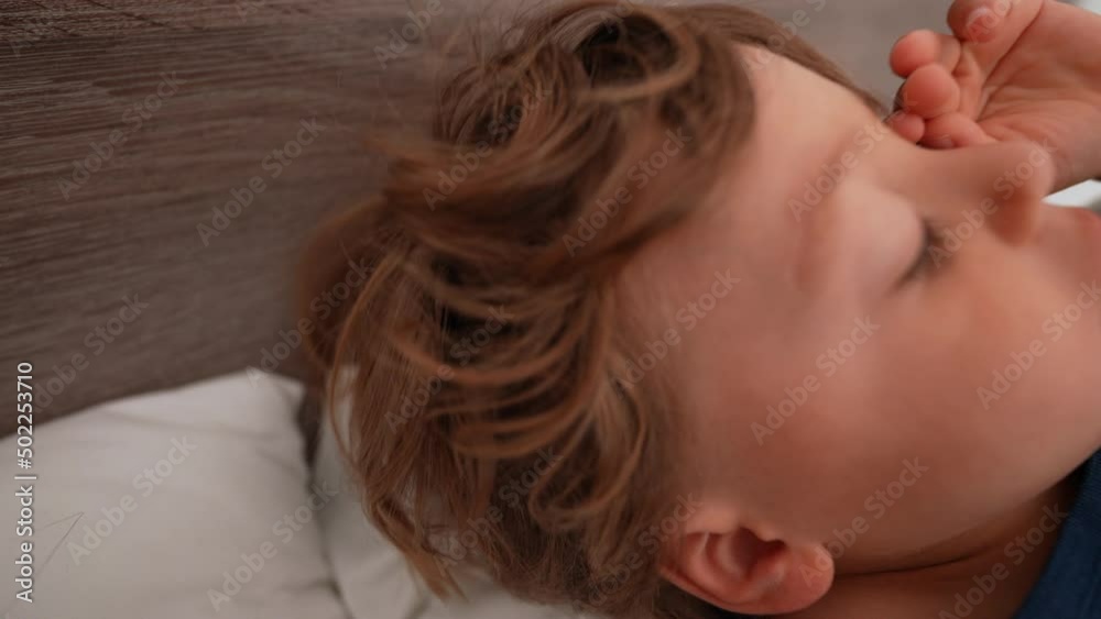 Child getting up from bed in morning rubbing eye next to mother kid wakes up Child getting up from bed in morning rubbing eye next to mother kid wakes up